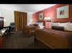 Two queen beds and a work desk inside a guest room.