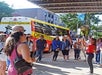 A tour group gathered in a circle listening to their tour guide at the  historic Biograph Theater with the Crime Tours bus in the background.