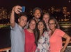 Group selfie under the Chicago skyline at night.