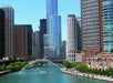 Chicago River with boats, a water cannon fountain, and the skyline featuring the glassy Trump Tower on a sunny day.