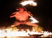 Performer spinning flames in a striking display.
