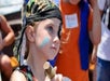 A kid with face paint on their face and an eye patch wearing a black bandana on their head on the Sea Gypsy pirate ship.