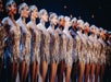 Close up of the Radio City Rockettes wearing shimmering silver costumes in a line on stage during the Christmas Spectacular.