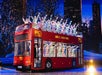 The Radio City Rockettes in red and white and green and white coats on a red double decker bus performing during the Christmas Spectacular.