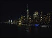 View of New York City at night with the Circle Line Harbor Lights Sightseeing Cruise in the water in NYC, New York.