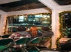 Passengers sit in the indoor cabin of the boat, admiring the breathtaking scenery outside through large windows with panoramic views