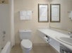 A single vanity mirror, fresh towels, toilet, shower, and tub in a private bathroom.