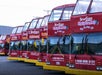A row of red double-decker Starline CitySightseeing tour buses parked side by side in a lot.
