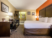 Guest room with a king bed, microwave, a fridge and a work desk