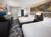 Guest room with two queen beds, a microwave and a fridge
