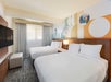 Bedroom with two beds, and a flat-screen TV