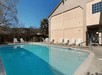 Seasonal outdoor pool with white lounge chairs lining the sides on a sunny day at Cloverdale Wine Country Inn & Suites.
