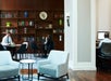 Guests in the sitting area in the Club Living Room and a bookshelf with plenty of books behind.