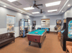 Game room with pool table and arcade games.