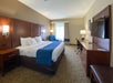 Guest room with 1 King bed, flat-screen TV, work desk and chair, and a comfortable soft seating.