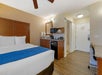 Guest room with one king bed, mini-fridge, coffee/tea maker, desk, and microwave.