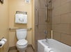 Bathroom with fresh towels, toilet, shower and tub with grab bars.