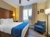 Guest room with one king bed, air condition, and a seating area.