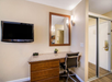 Flat screen TV, a desk and chair, and closet in a guest room.