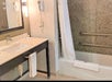 Private bathroom with sink & mirror and bath tub.