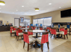 Breakfast area with modern furniture, and a selection of breakfast items and a flat-screen TV.