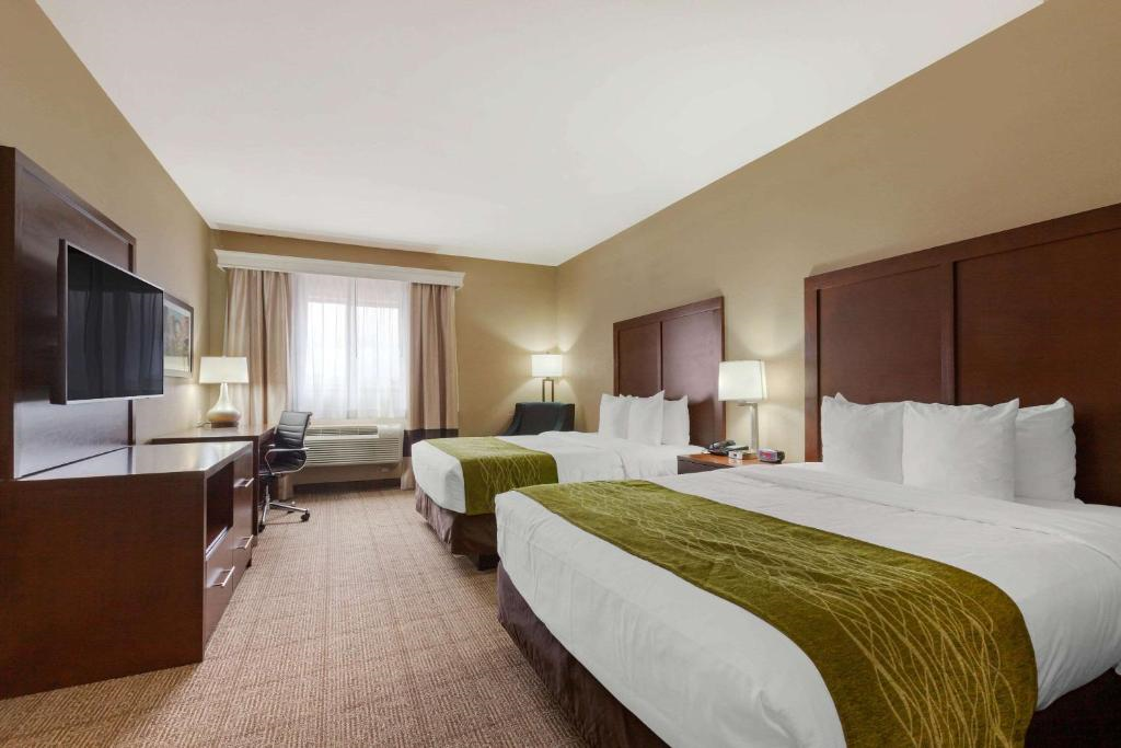A well-appointed room with two queen beds, a TV for entertainment, and a work desk for convenience.