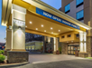 Hotel entrance with a banner announcing "Now Open! Indoor Pool." Illuminated with lights and featuring a modern design.