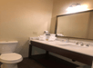A hotel bathroom with a large mirror, sink and toilet at the Comfort Inn & Suites Ukiah Mendocino County.