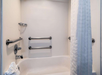 Accessible tub equipped with secure grab bars for added safety.
