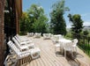 A wooden deck with white plastic chairs and tables on a sunny day at Comfort Inn at Thousand Hills in Branson, Missouri.