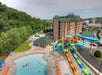 Aerial view of a water park featuring colorful water slides, a pool, and a hotel building.