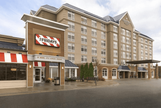 The front exterior of the Country Inn & Suites by Radisson and the TGI Fridays to the left of it in Bloomington, Minnesota.