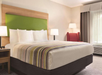 Guest room with a king bed, and an armchair