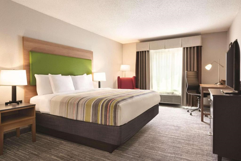 Guest room with a king bed, work desk, a sleeper sofa, and TV