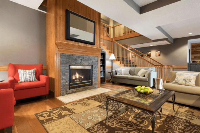 A seating area in the lobby of the Country Inn & Suites with several couches and chairs, a coffee table, and a large fireplace.