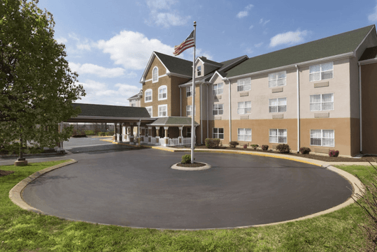 Beautifully landscaped entrance to the hotel with a poll and The American Flag.