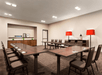 A meeting room with long tables shaped like a "U" with a small coffee bar on the side wall at the Country Inn & Suites.