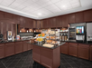 Breakfast area with a variety of breakfast items, assorted fruits, juice machine and more.