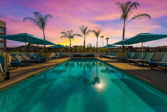 Catch the sunset at the outdoor rooftop pool with sun loungers and umbrellas.