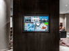 A dark brown wall with a TV built into it and a lounge area visible behind it at the Courtyard Columbus Easton.