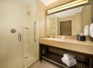 Fresh towels, complimentary toiletries and a glass-enclosed shower inside a private bathroom.