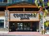 Front entrance of Courtyard Marriott hotel, featuring a stone facade and large signage, with some greenery in the foreground.
