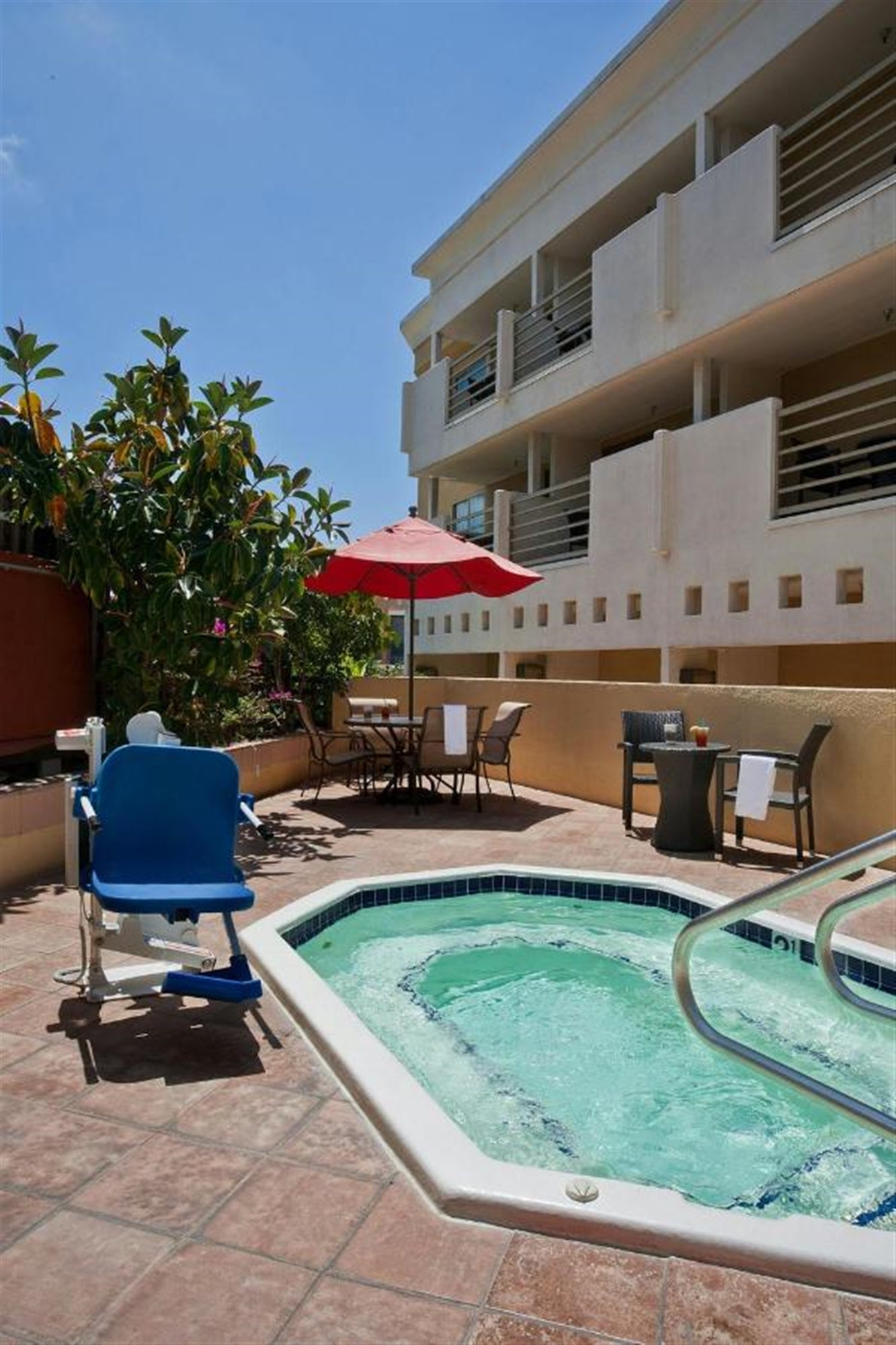 Hot tub on property with tables and chairs beside it.