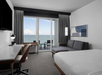 Guest room with 1 King bed, sofa bed, work area, wall-mounted TV, and a private balcony and oceanfront views.