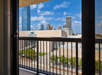 View from a balcony overlooking the city skyline, including tall buildings and the Cox Convention Center on a clear day with blue skies.
