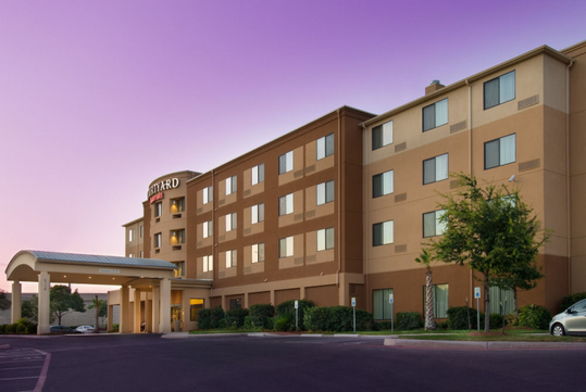 Beautifully landscaped entrance to the hotel with the hotel sign.