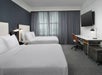 Guest room with 2 Queen beds, a wall-mounted TV, and a working area.