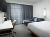 Guest room with 1 King bed, a wall-mounted TV, sofa bed, and a working area.