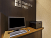 Computer and printer on a wooden desk beneath a "Boarding Pass" sign.