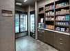 Hotel snack shop with refrigerated drinks, shelves of snacks, and a microwave.